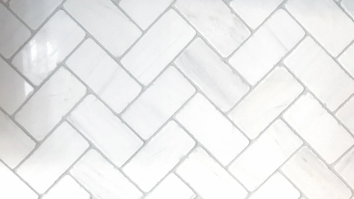 Clean grout between angled, white subway tiles