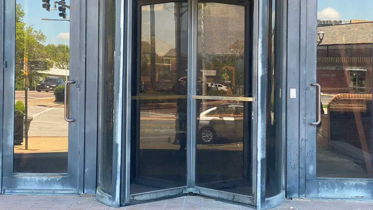 Old condition of painted aluminum revolving door prior to being restored by Mid America Specialty Services